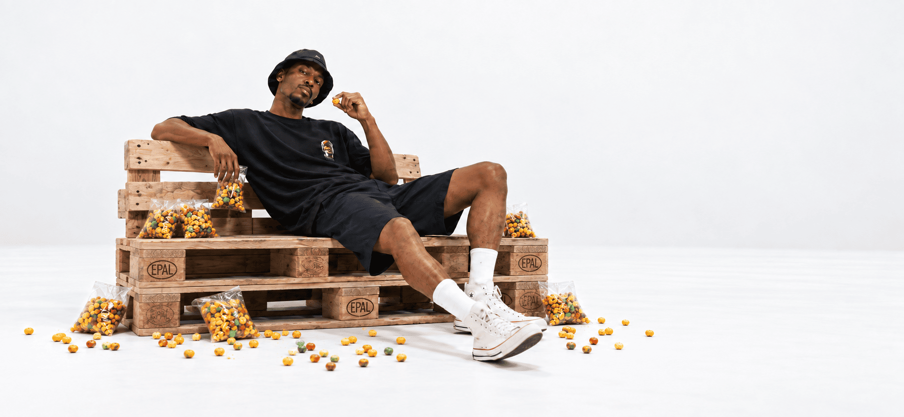 Elliot Sithole Skopas campaign: a relaxed graphic tee look on a wooden bench